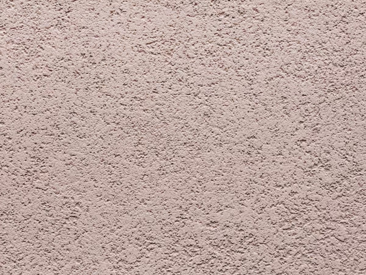 Gros plan d'un crépi rose poudré.