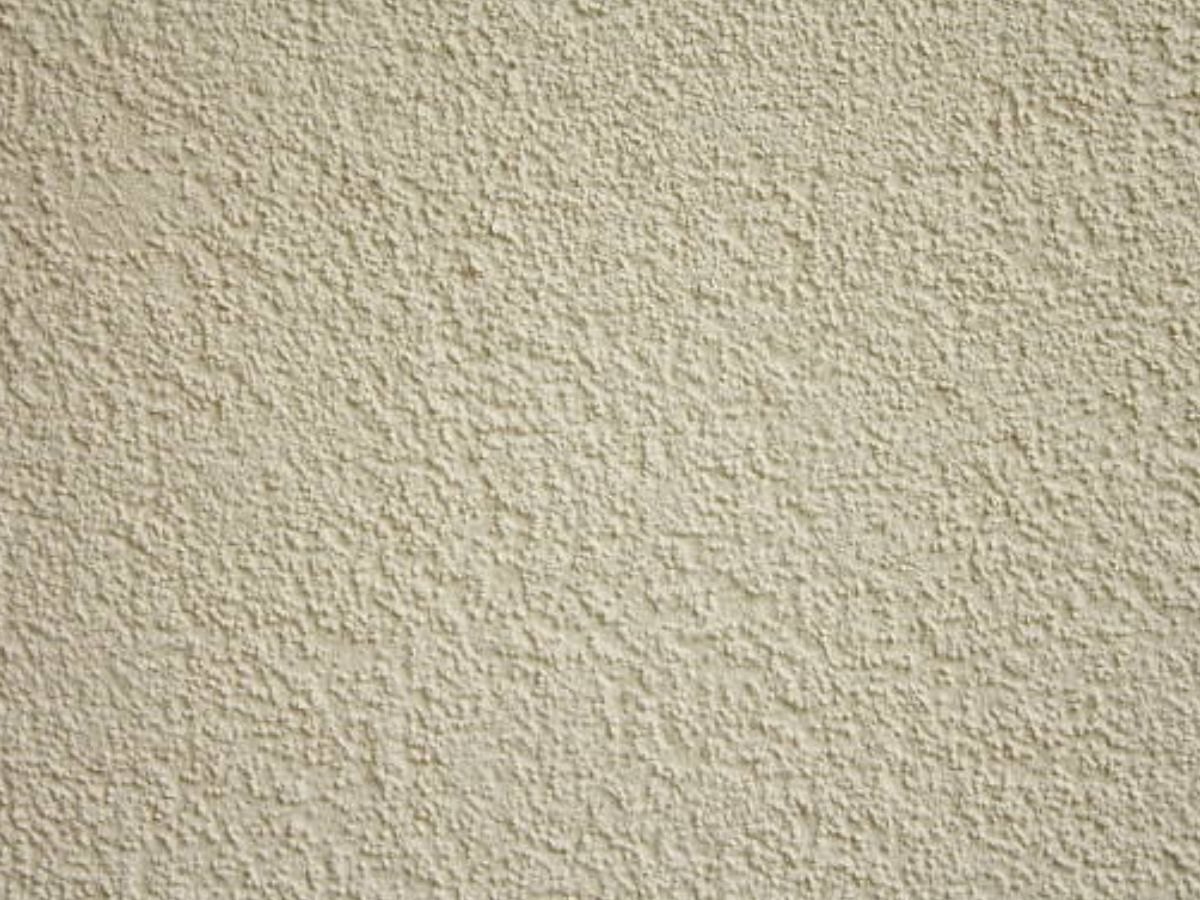 Gros plan d'un crépi beige sable.
