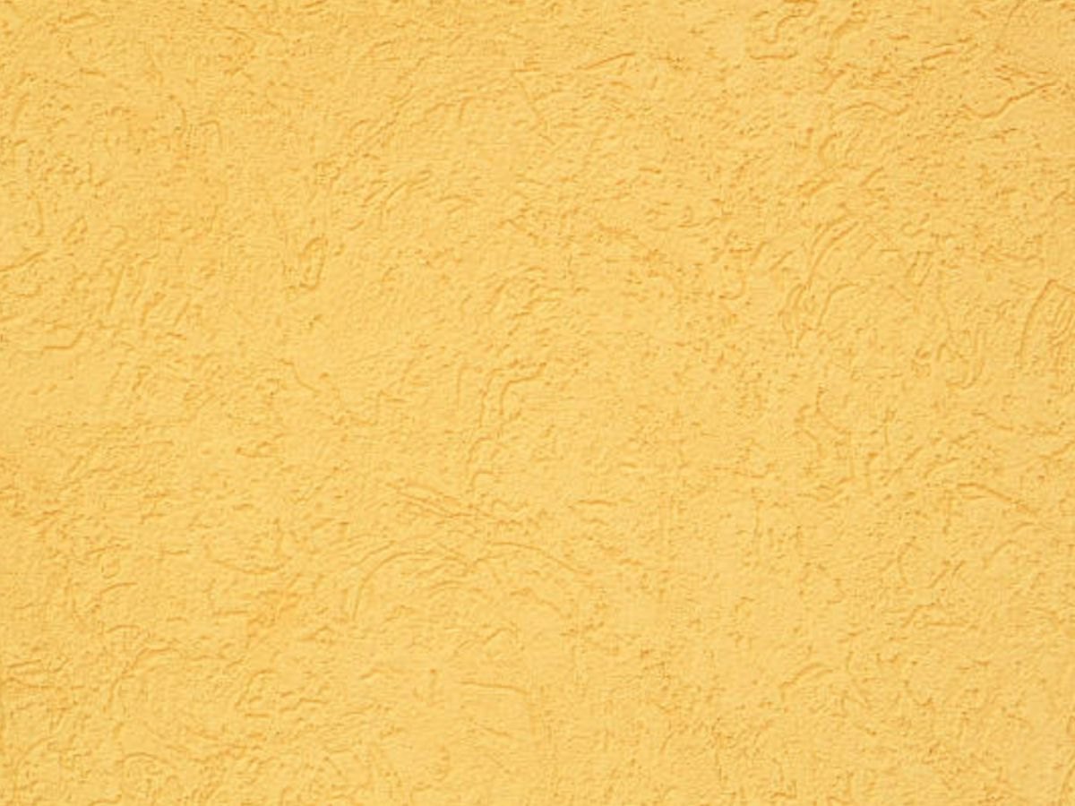 Gros plan d'un crépi jaune.